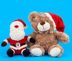 little teddy bear in red christmas hat and santa claus photo