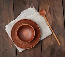 empty brown ceramic plates on a wooden table photo