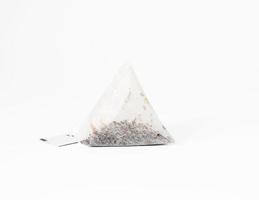 bolsa de té desechable triangular sobre una cuerda, fondo blanco foto