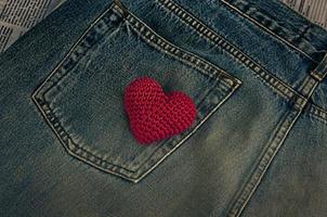 Small knitted red heart on jeans pocket, vintage style photo