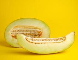 piece of ripe melon with seeds on a yellow background photo