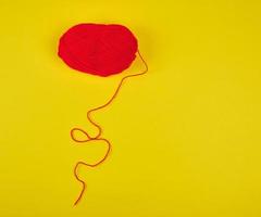 big skein of red wool on a yellow background photo