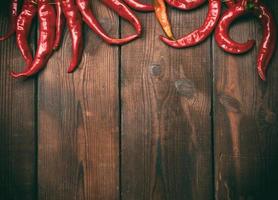 ripe red chili peppers on a brown wooden vintage background photo