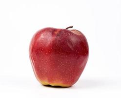 red ripe apple with defects on a white background photo