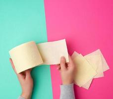 roll of yellow toilet paper in female hands photo