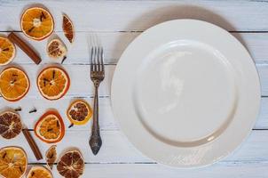 White empty plate with a fork on a white vintage wooden surface, photo