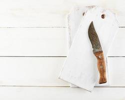 tabla de cortar de madera vacía y cuchillo viejo en el fondo blanco foto