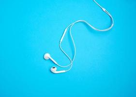 white earphones with a cable on a blue background photo