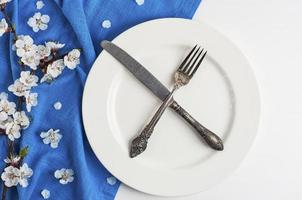 cuchillo cruzado y tenedor en un plato blanco vacío foto