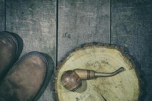 Wooden smoking pipe tobacco with a pair of leather boots photo