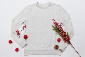 Close up blank template shirt, gray sweatshirt hoodie with copy space and Christmas Holiday concept. Top view mockup sweater isolated on white background. Happy New Year decorations. Xmas jamper photo