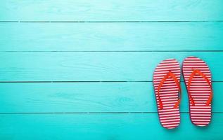 red flip flops on blue wooden background top view free space photo