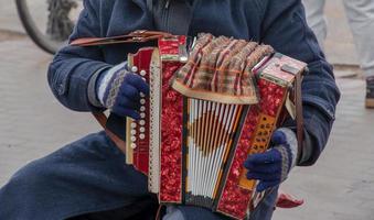 Close-up of a man's hand playing button accordion outdoors in winter. photo