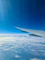 vista desde un avión hacia el ala y las nubes debajo. foto