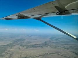 View from an aircraft onto the wing and the savannah in Kenya below. photo