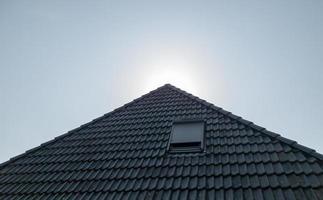 Open roof window in velux style with black roof tiles. photo