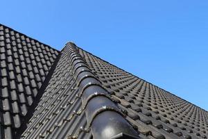 Roof window in velux style with black roof tiles. photo