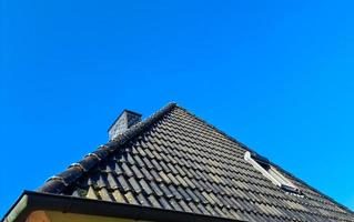 Open roof window in velux style with black roof tiles. photo