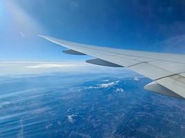 vista desde un avión hacia el ala y las nubes debajo. foto