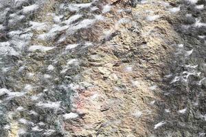 Close up view at a granite and stone wall texture in a high resolution. photo