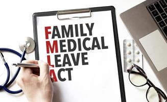 Doctor holding a pen and card with text family medical leave act, medical concept photo