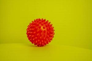 Red spike ball on yellow background photo