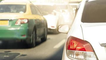 luz trasera del coche blanco conduciendo por la carretera asfaltada. abstracto y borroso de autos en el tiempo de tránsito en el día en la ciudad. foto