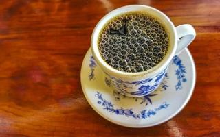 Blue white cup pot with black coffee wooden table Mexico. photo