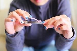 cut nails concept, woman hand holding nail clipper and cutting nails hand - fingernail health care photo