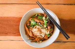 chicken noodles with chicken feet and chicken wings and vegetable on soup bowl , Thai food photo