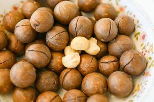 macadamia nuts on bowl, fresh natural shelled raw macadamia nuts, close up pile of roasted macadamia nut photo