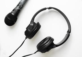 micrófono negro y auriculares aislados para música y podcast en diseño de fondo de diseño plano foto