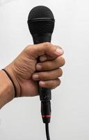 Hand holding black microphone isolated photo