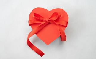 Heart gift box with red ribbon tie. Love shape design element photo