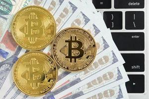 moneda de bitcoins dorada y billetes estadounidenses con computadora de teclado foto