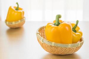 Fresh yellow bell peppers in basket photo
