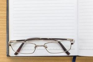 Notebook open blank page and Eyeglasses photo
