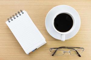 Coffee and notepad on wood table photo