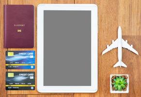 Top view Passport with credit card and digital tablet mock up on wooden desk