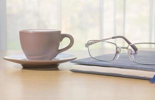 Glasses and book on the desk photo