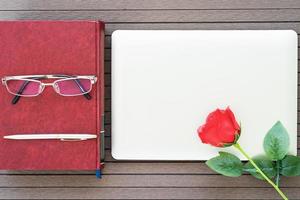 Office desk table with laptop,notebook,red rose photo