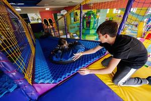 niños jugando en el patio interior del centro de juegos en tubos. foto