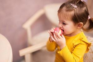 Baby girl eat delicious tasty sweet color macaron. photo