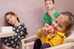 Three kids eat delicious tasty sweet color macarons. photo