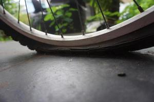 flat bicycle tire in front of the house in the morning photo