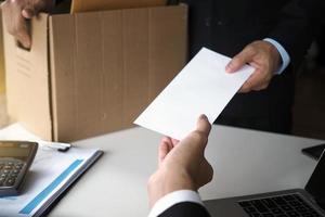 la empresaria tiene una caja de cartón marrón junto a su cuerpo y envía una carta de renuncia al ejecutivo. incluyen sobre renuncia, colocación de trabajo y vacantes. foto