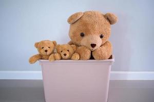 A group of brown-haired teddy bears in a pink box. Background for children photo