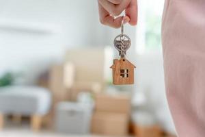 Moving house, relocation. Woman hold key house keychain in new apartment. move in new home. Buy or rent real estate. flat tenancy, leasehold property, new landlord, dwelling, loan, mortgage. photo