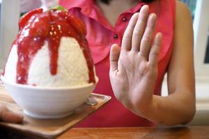 Women push Bingsu cup. Refused to eat all kinds of sweets. Avoid sugar and sweets for good health. diet concept photo