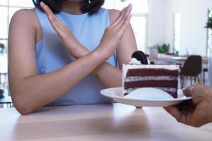 las niñas usaron una mano para empujar un plato de pastel de chocolate foto